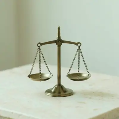 A small brass balance scale on pale stone